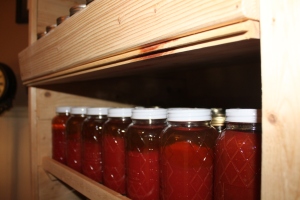 The shelves of the pantry stocked with tomato juice from the garden