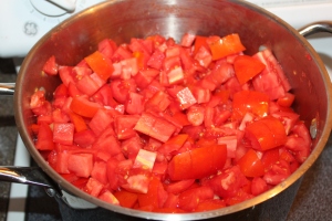 Freshly chopped tomatoes  beginning to cook down on the stove