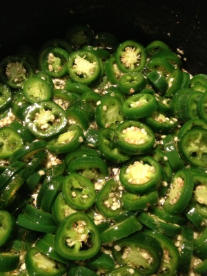 Add sliced jalapenos to the hot liquid and boil before adding to mason jars. 
