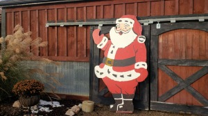 Santa posing for a picture in front of the barn